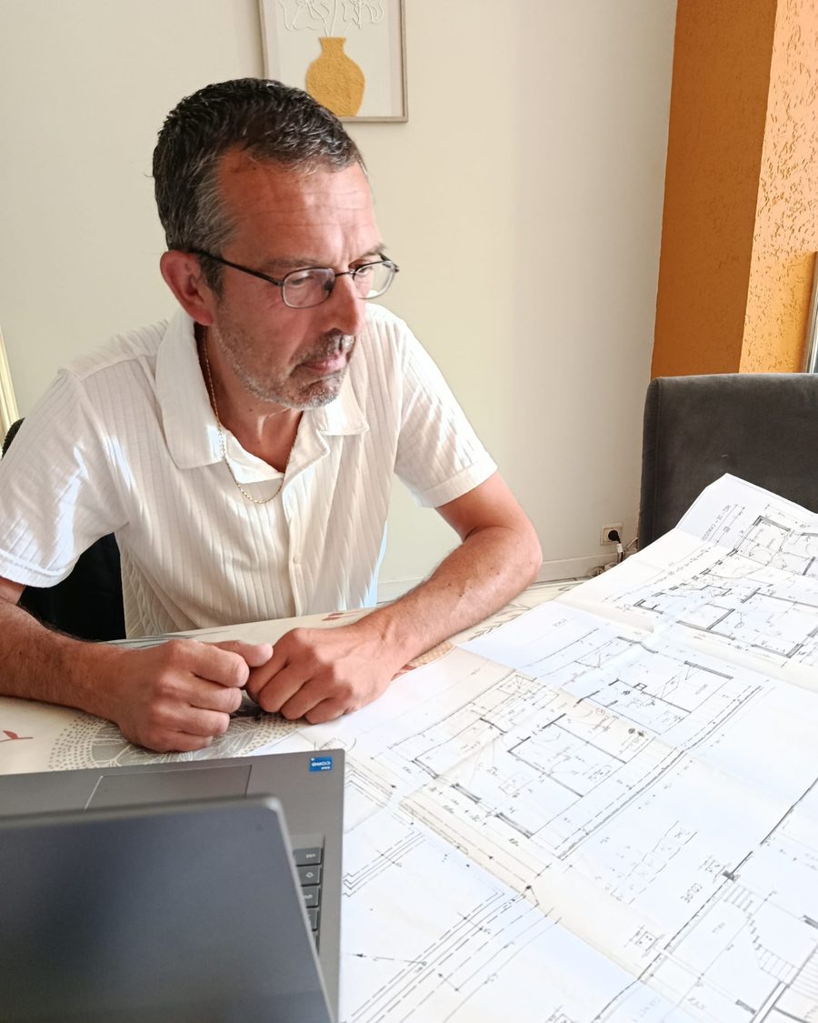 Yves Van Eeckhout, consultant en prévention incendie, étudiant les plans d'un bâtiment.